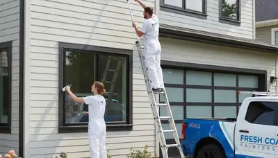 Professional painters applying durable siding paint on Detroit MI home exterior